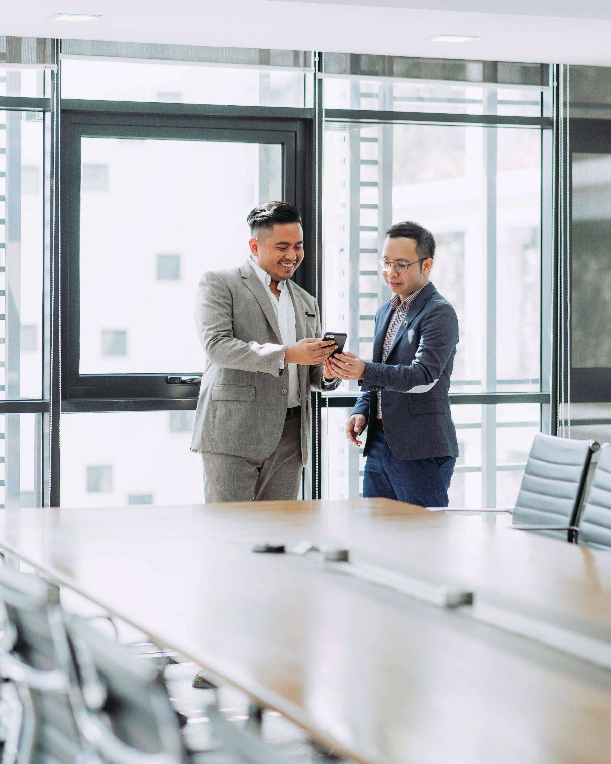 2 Executives using mobiles in the meeting room